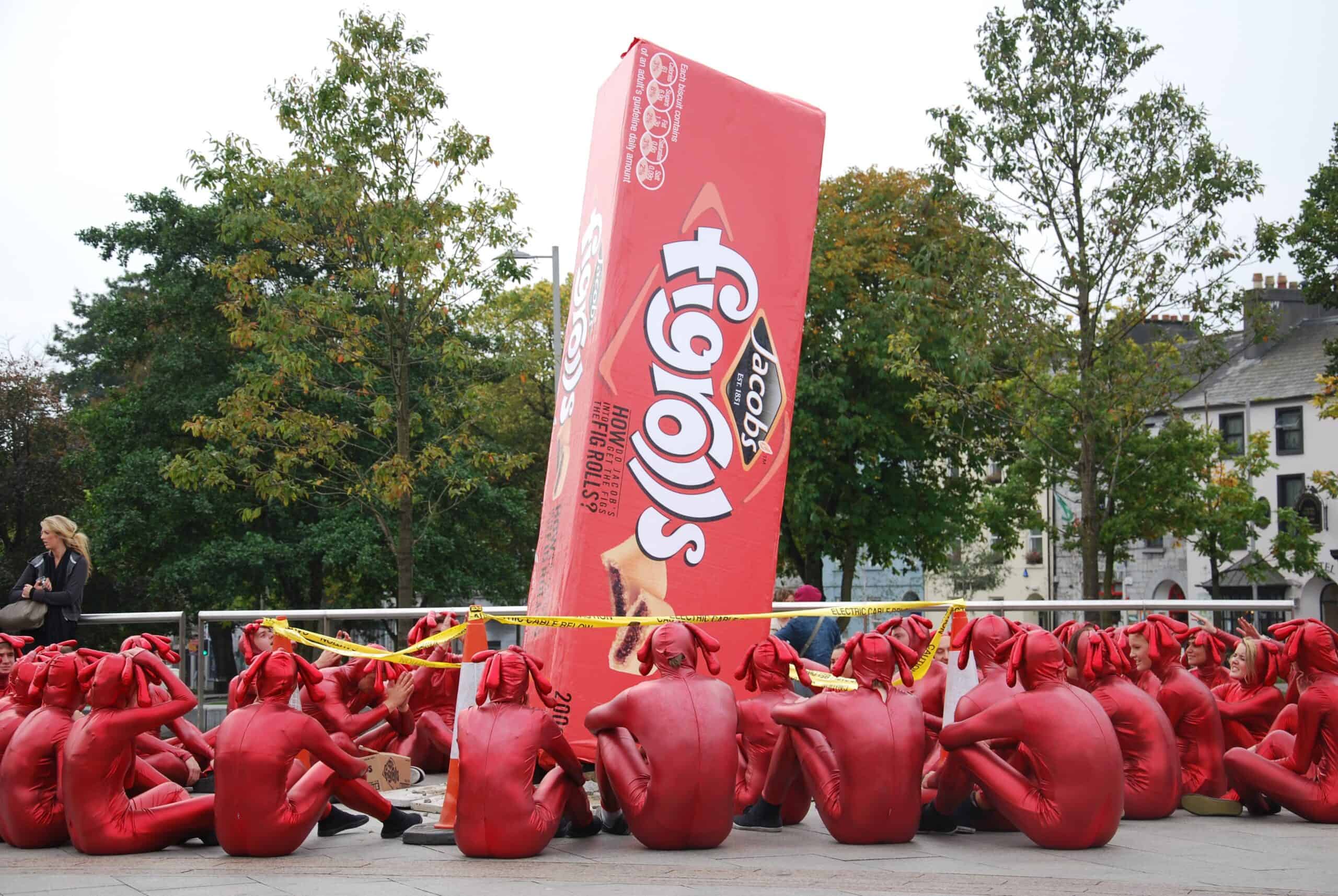 a large display of Jacobs figrolls for an outdoor event, surrounded by people in red costumes
