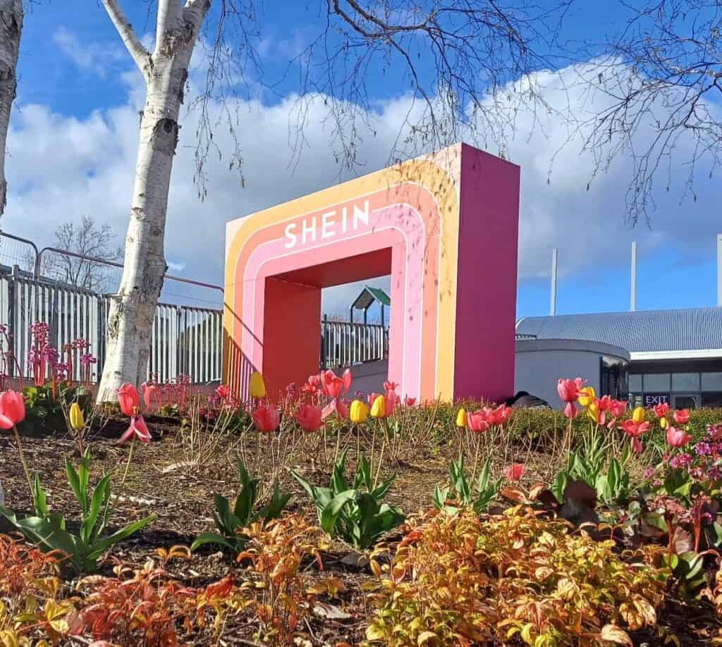 a large custom-built display arch for Shein in pinks and oranges, with a field of tulips in the foreground