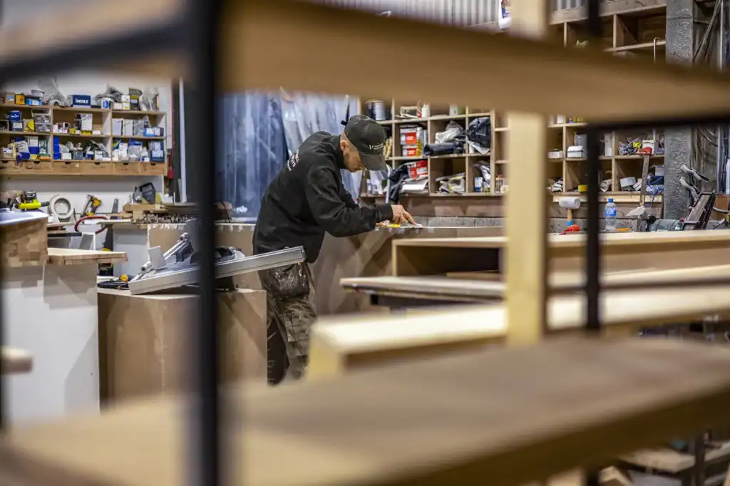 a man measures materials for a sustainable exhibition stand
